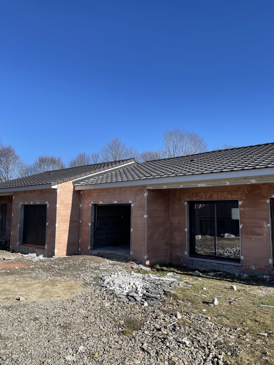 Maison neuve de plain-pied en briques monomur rouges, avant enduit de façade