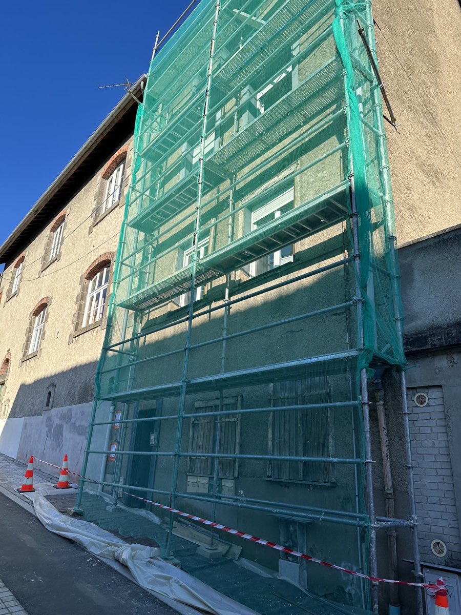 Immeuble de ville sous échafaudage, façade grise encrassée avant ravalement