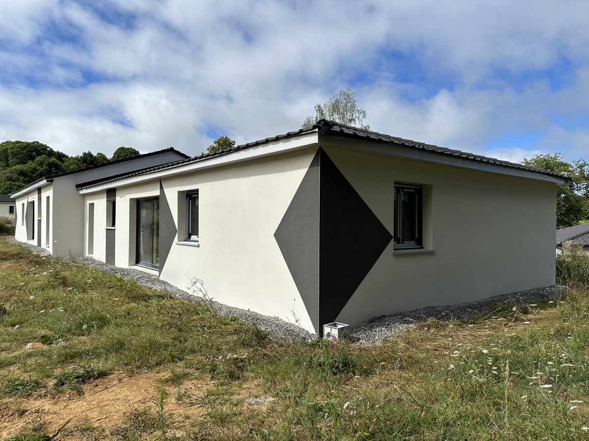 Maison neuve avec un motif losange anthracite peint dans l'enduit clair, réalisé par REIS façade