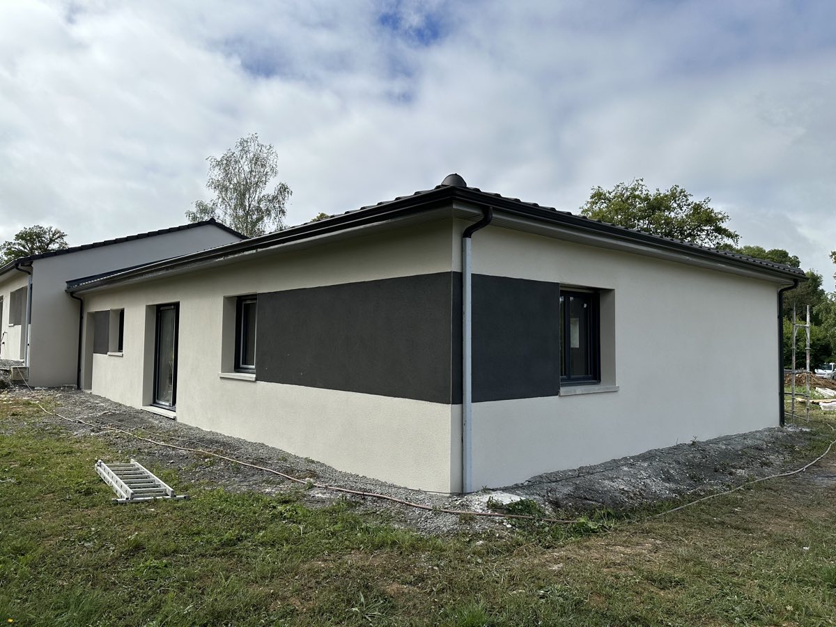Angle de maison neuve avec enduit bicolore crème et anthracite, réalisé par REIS façade