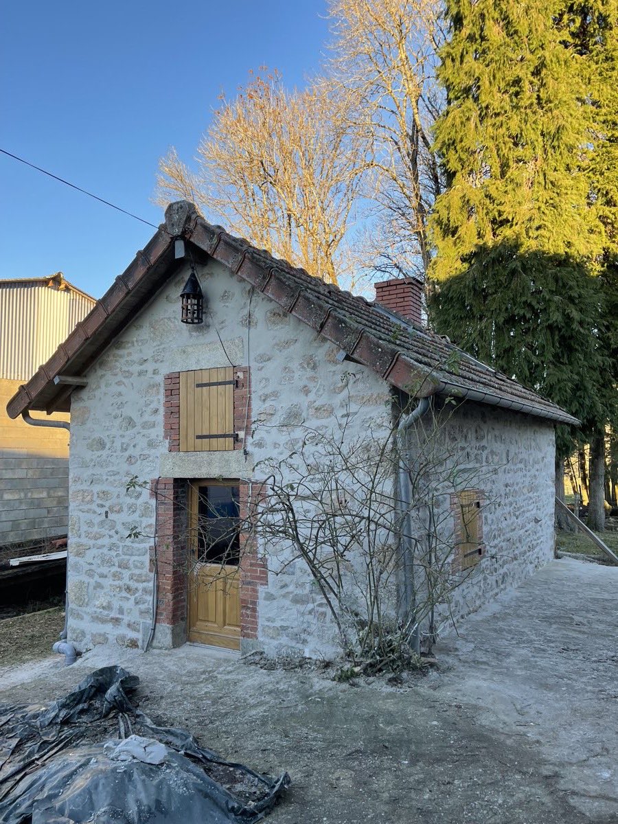 Façade d'une dépendance ancienne en pierre apparente restaurée par REIS façade