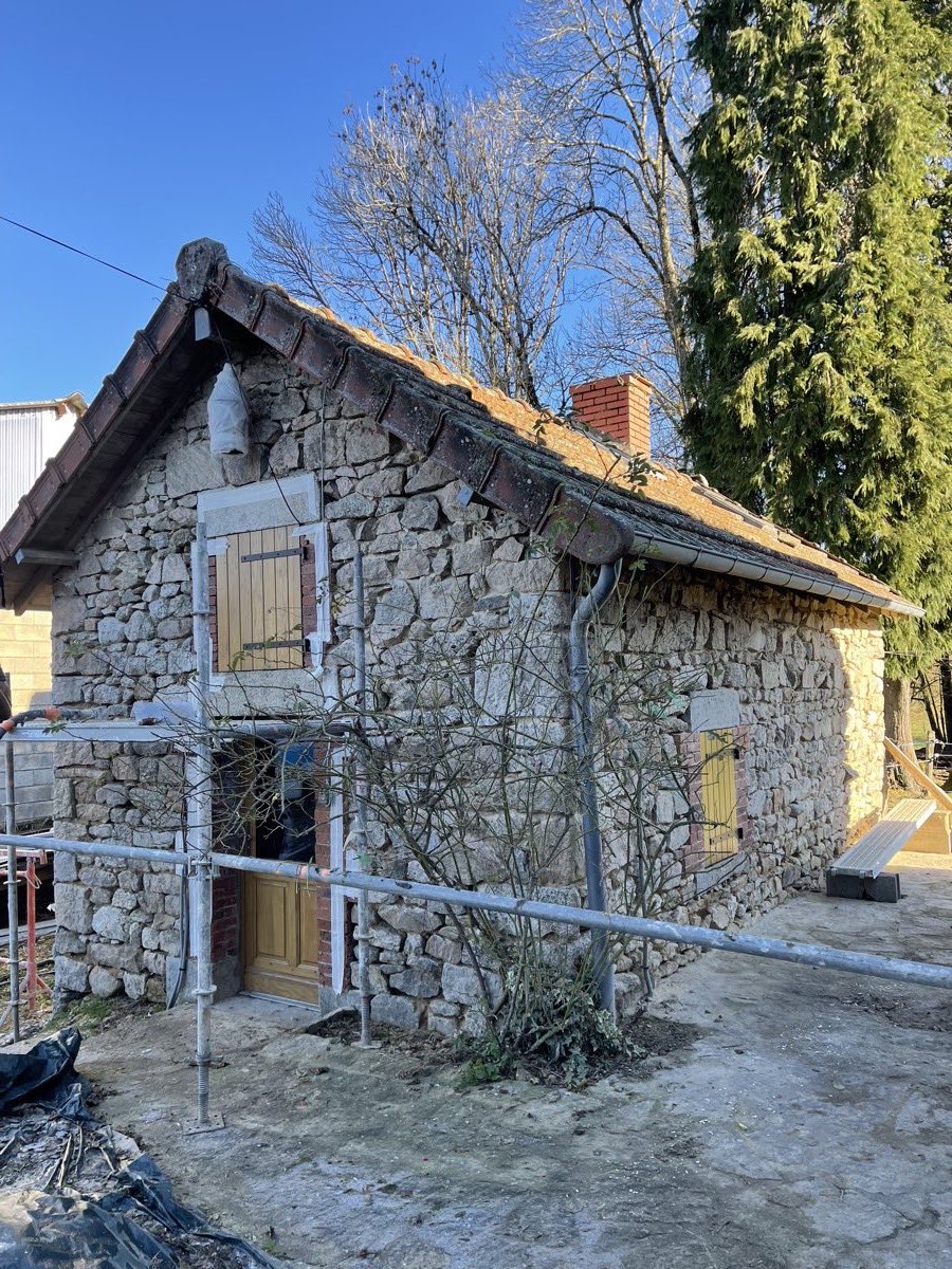 Vue d'ensemble d'un bâtiment ancien en pierre apparente pendant sa restauration