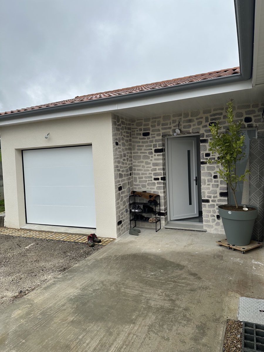 Maison contemporaine avec pan de mur en enduit imitation pierre gris